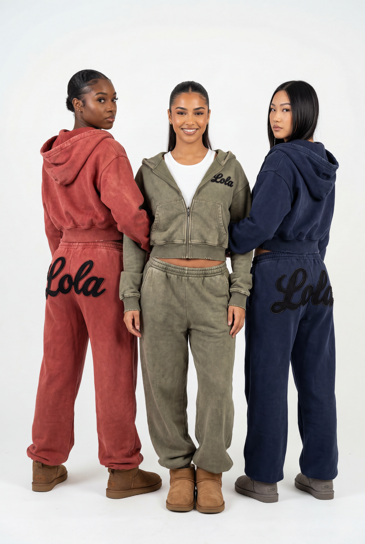 three women in a studio wearing different colored vintage sweatsuits.