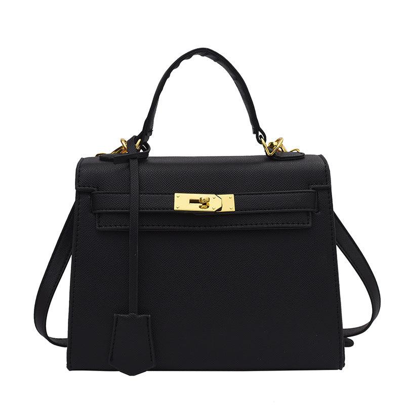 Black handbag with gold hardware on a white background