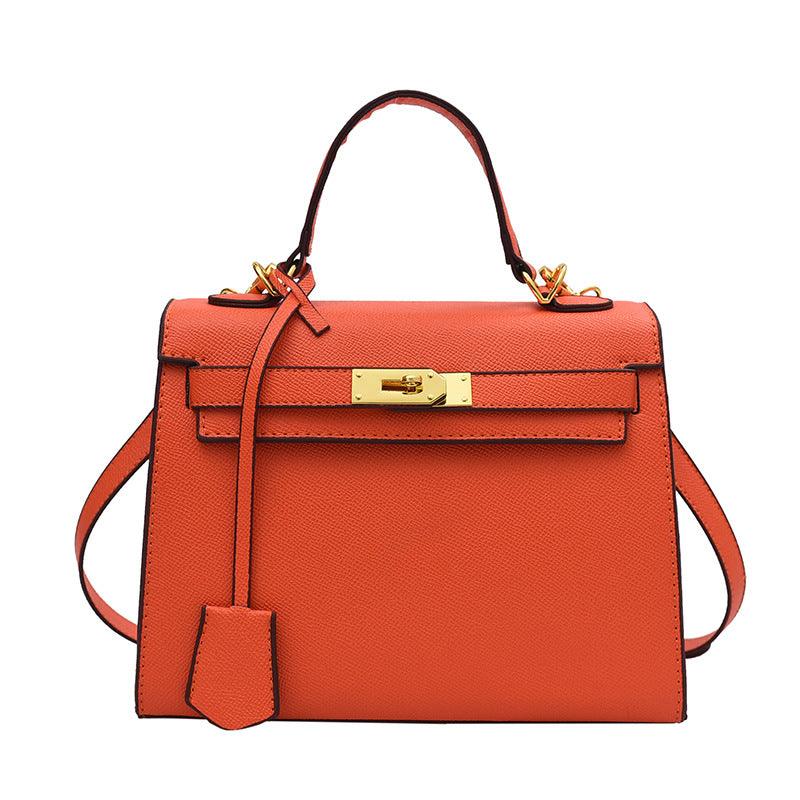 Orange handbag with gold hardware on a white background