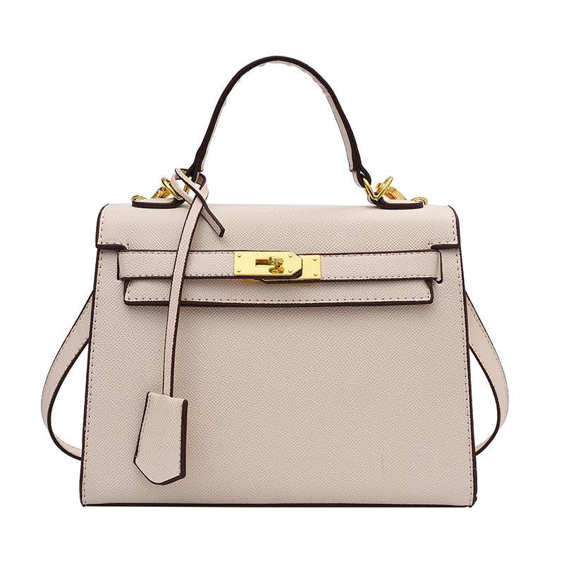 Beige handbag with gold hardware on a white background
