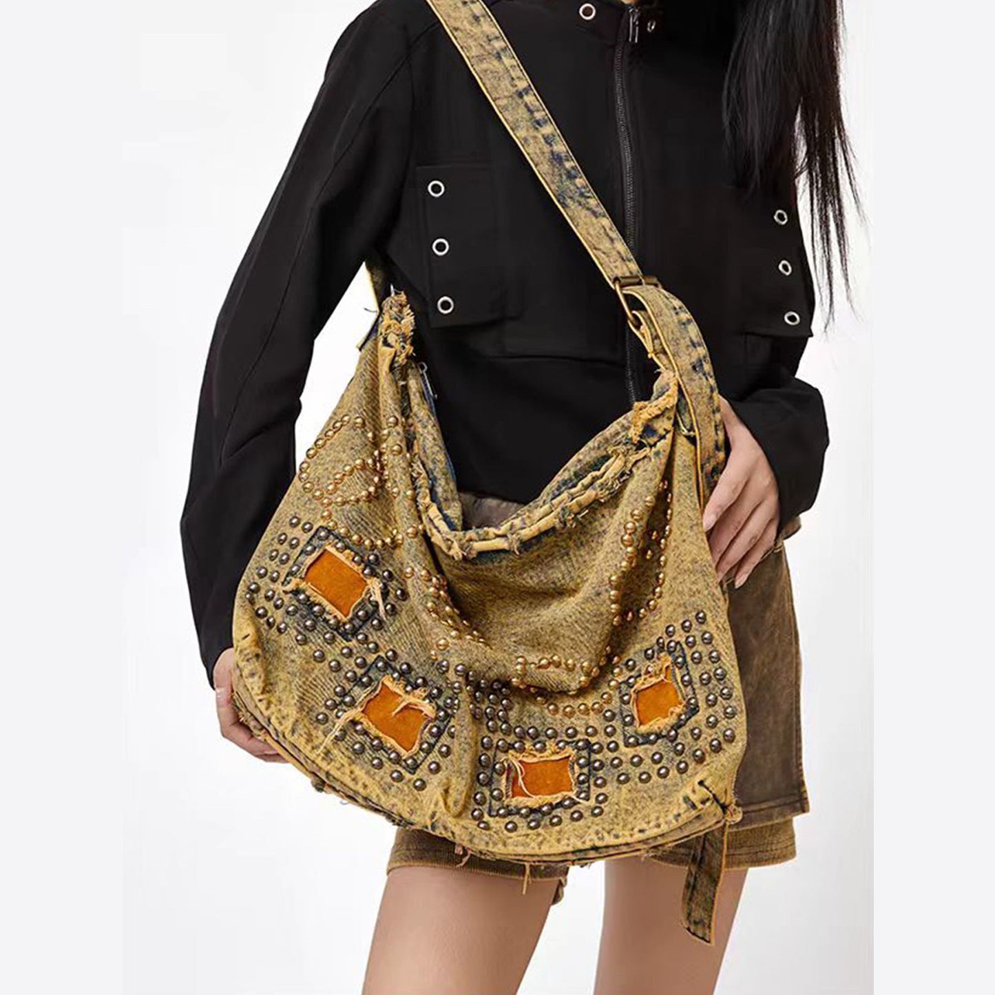 Person holding a gold embellished handbag against a white background