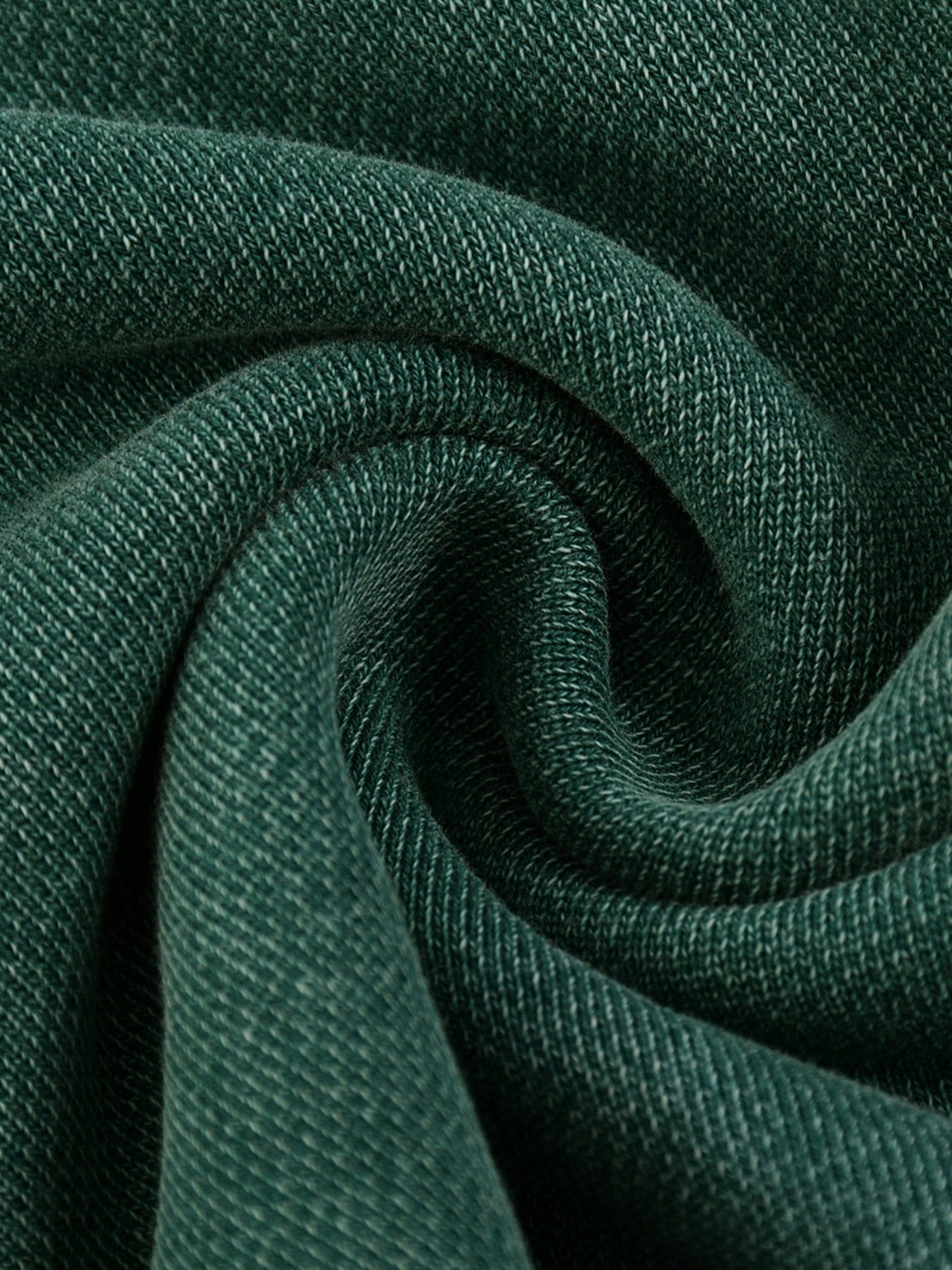 Close-up of dark green fabric with a textured pattern, showcasing the products thick heavy weight fabric for the women's sweatsuit.