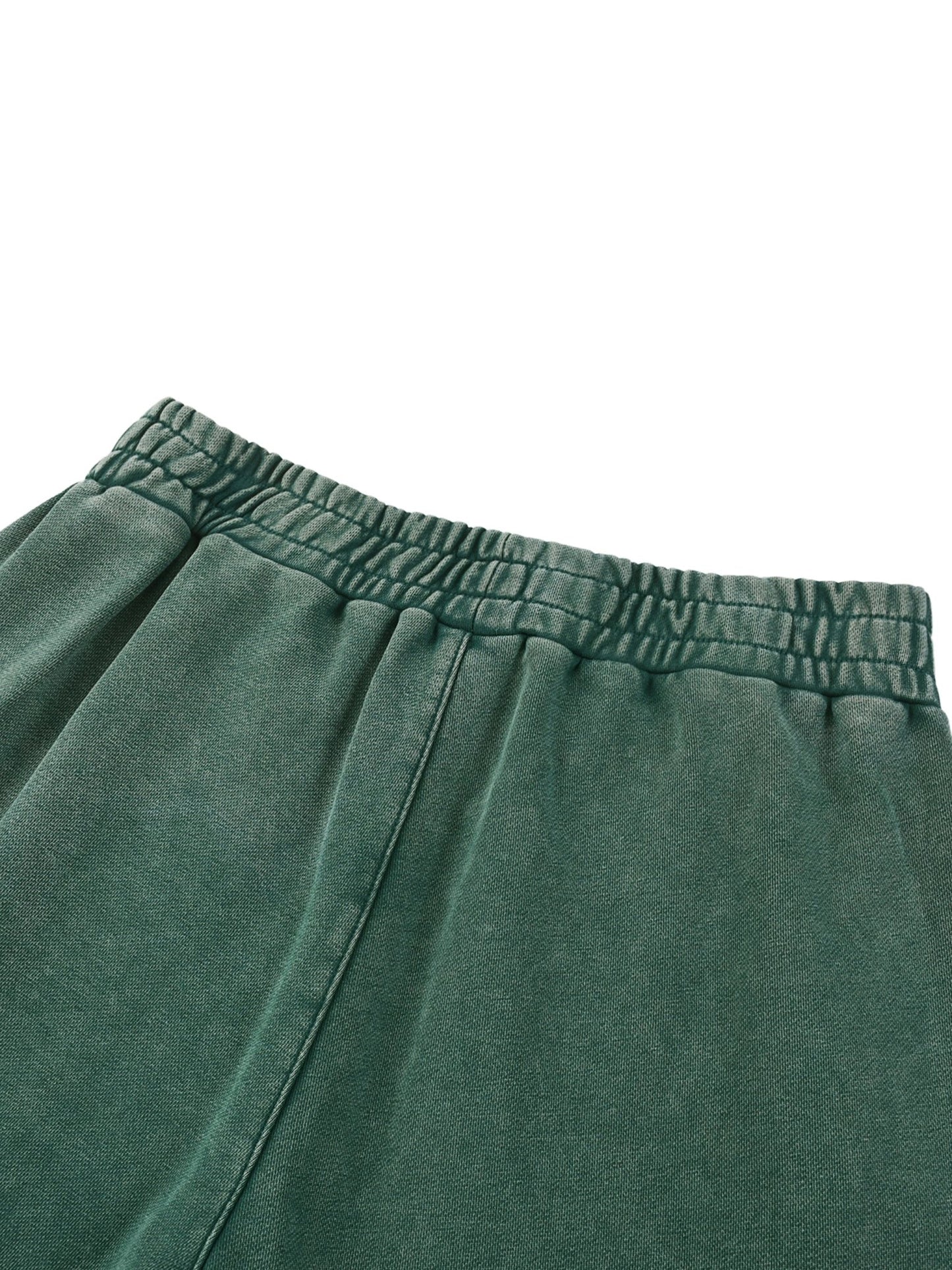 Close-up of green sweatpants with an elastic waistband on a white background