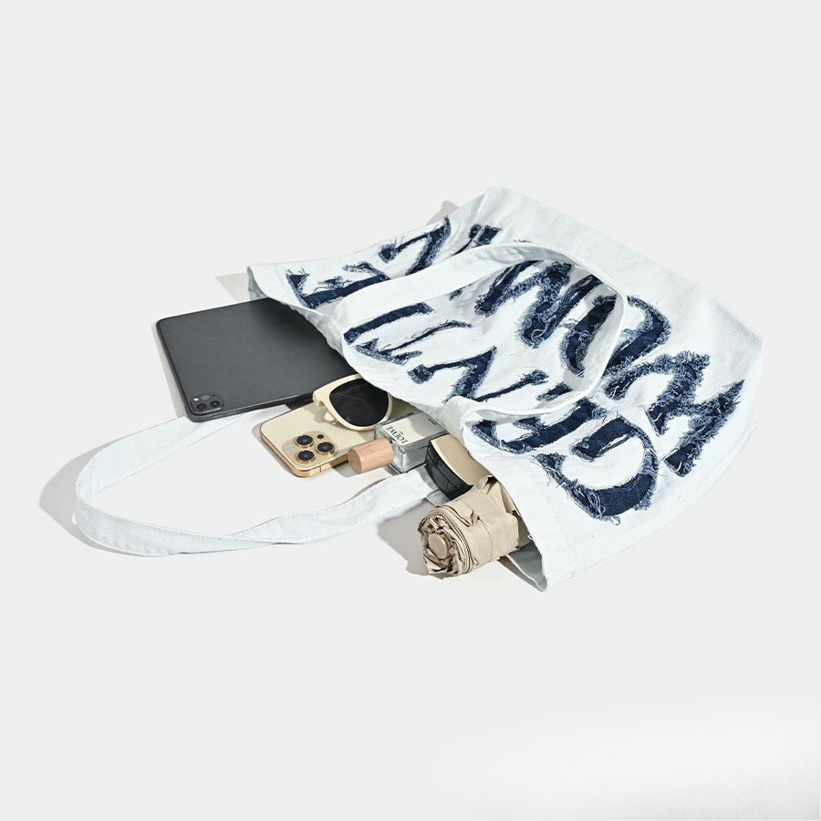Phone, wallet, and keys on a white surface with a towel draped over them.