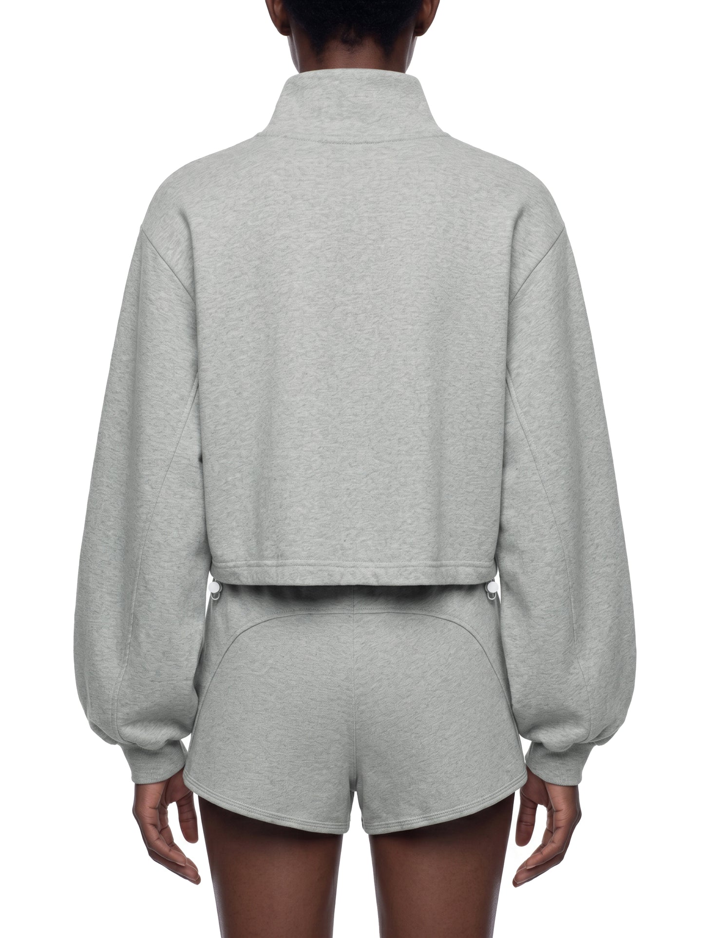 model wearing a gray crop sweatshirt, view is of back side, on a white background