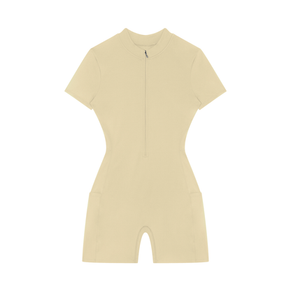 Beige gym romper with a quarter zip on a white background