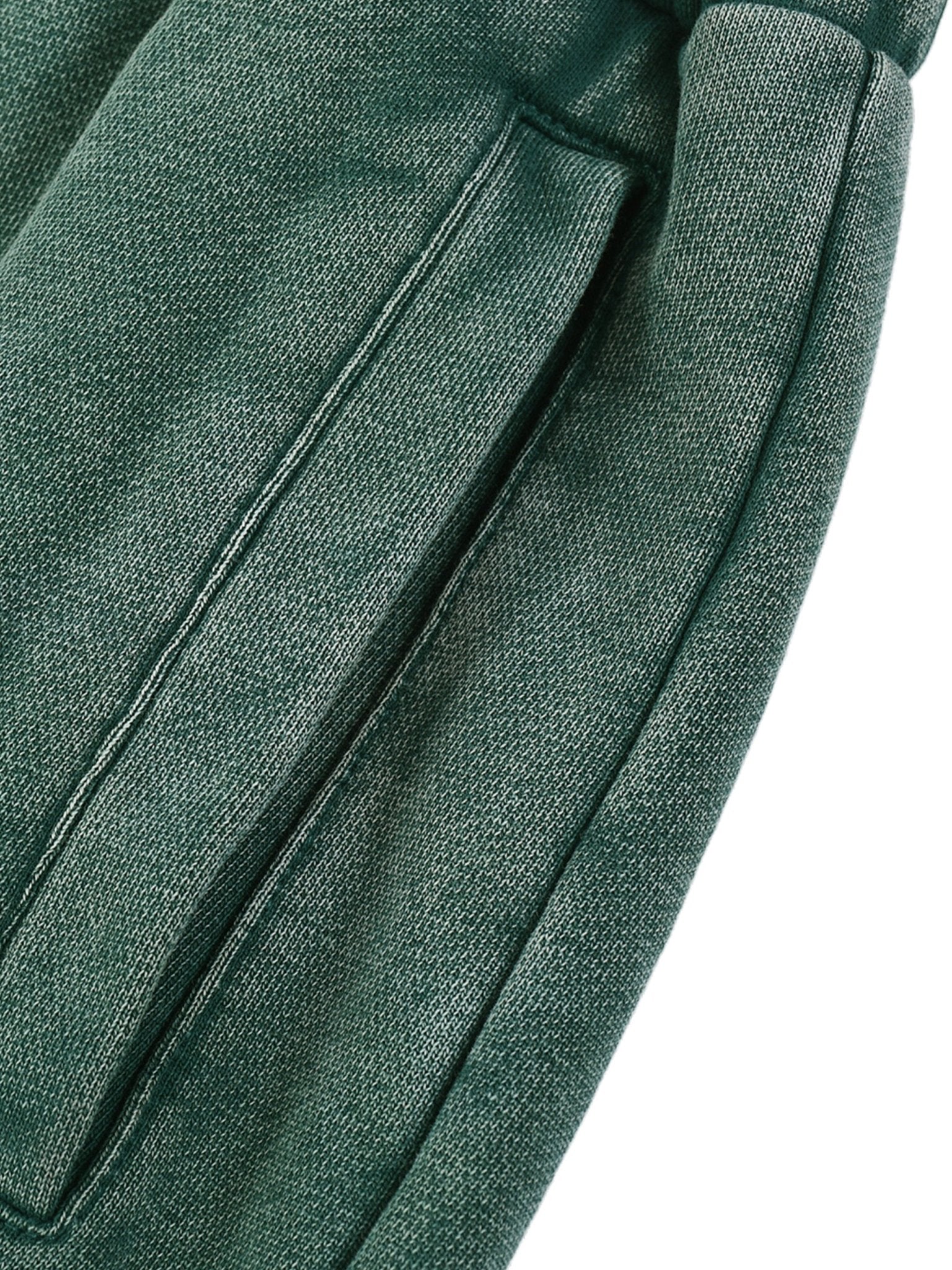 Close-up of green sweatpants fabric with a white background